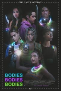 The seven cast members of bodies bodies bodies are stood in darkness, the only illumination being the lights from their phones and glowsticks around their necks and wrists
