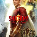 The titular character, Shazam, stands facing to the viewer. Behind him is a lightning bolt and the floating heads of several cast members.