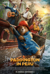 Paddington hangs off the side of the river boat by his umbrella as the rest of the Brown family, the boat's captain and the reverend mother are seen in the background